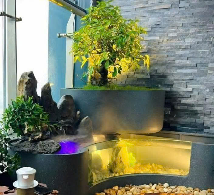 Bể cá mini kết hợp thác đá ở góc ban công, có đèn âm nước